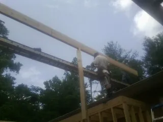 Carpenter setting a ridge beam over a new addition frame — Ice Dam Removal by Roofing Brothers in Pavo