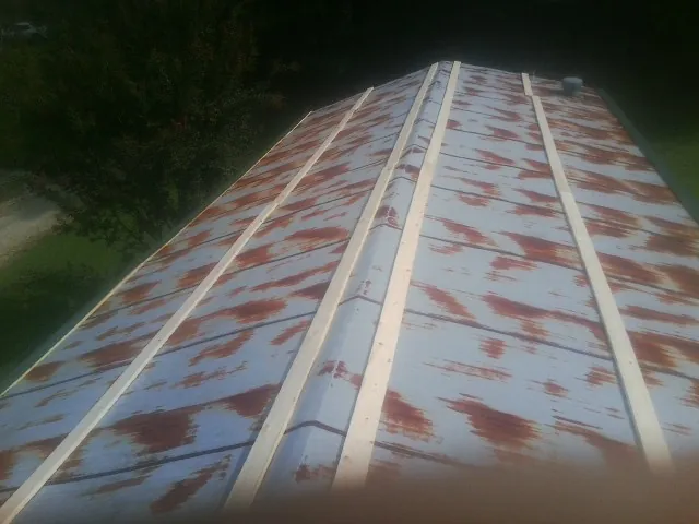 Rusted metal roof panels with new wood purlins before replacement — Storm Damage Roof Repair in Pavo by Roofing Brothers